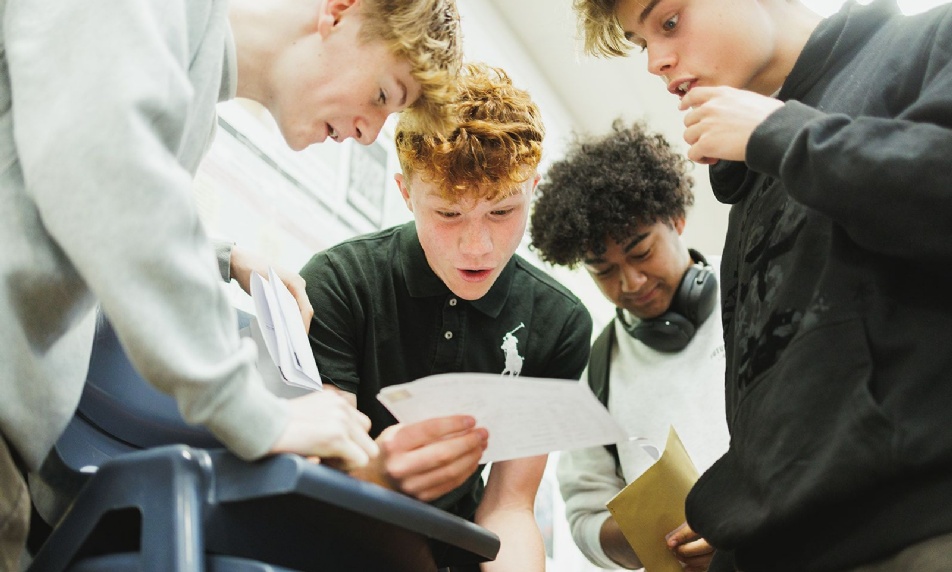 Image of past students receiving their GCSE results